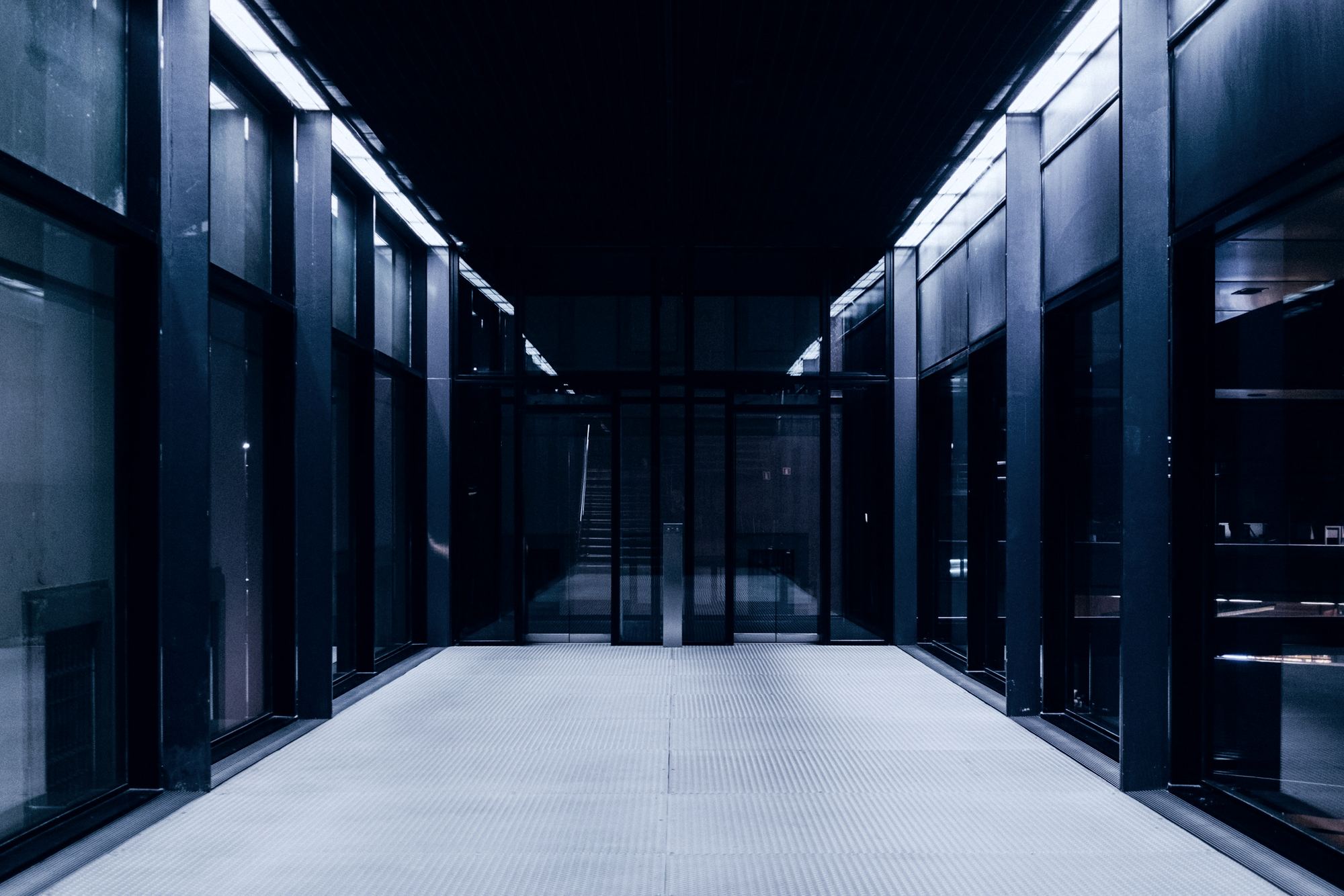 A long, dimly lit corridor of glass and steel
